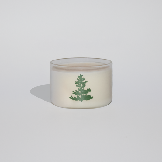Small glass container with a green leaf design on a white background