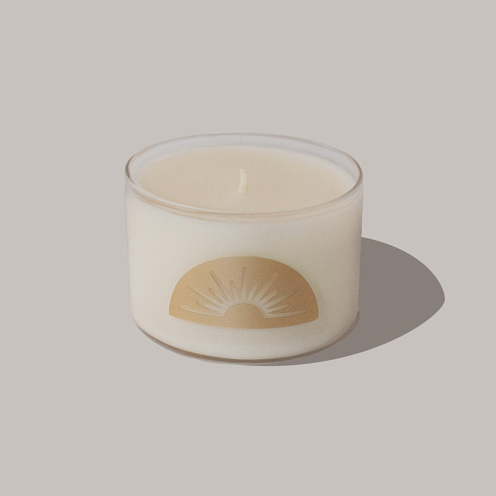 Candle with a sun design on a plain background