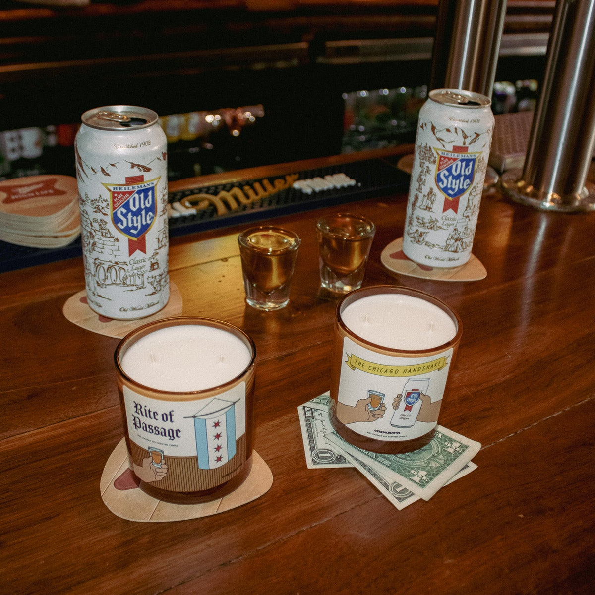 Two cans of Schlitz beer on a bar with shot glasses and money.